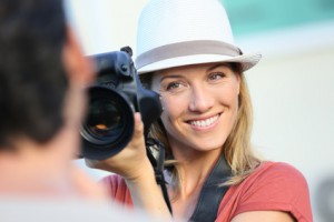 Woman photographer taking picture of model outside